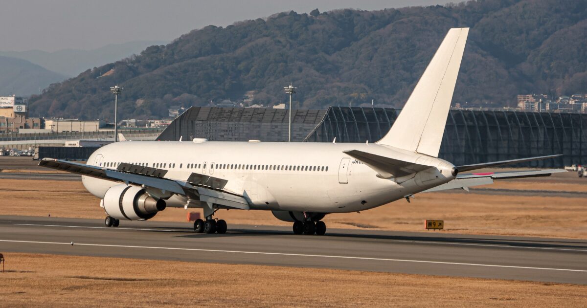 滑走路に着陸した白色の大型ジェット旅客機