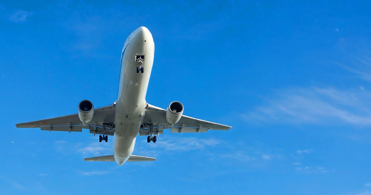 青空の下で真下から撮影した着陸態勢のジェット旅客機