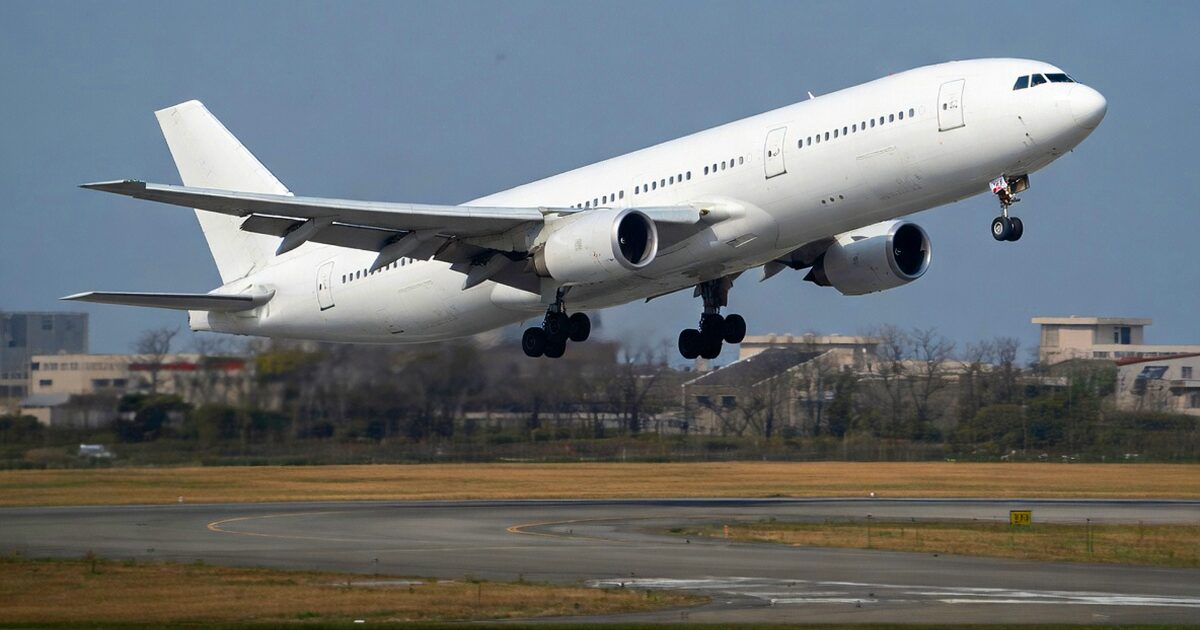 滑走路から離陸する白色の大型ジェット旅客機