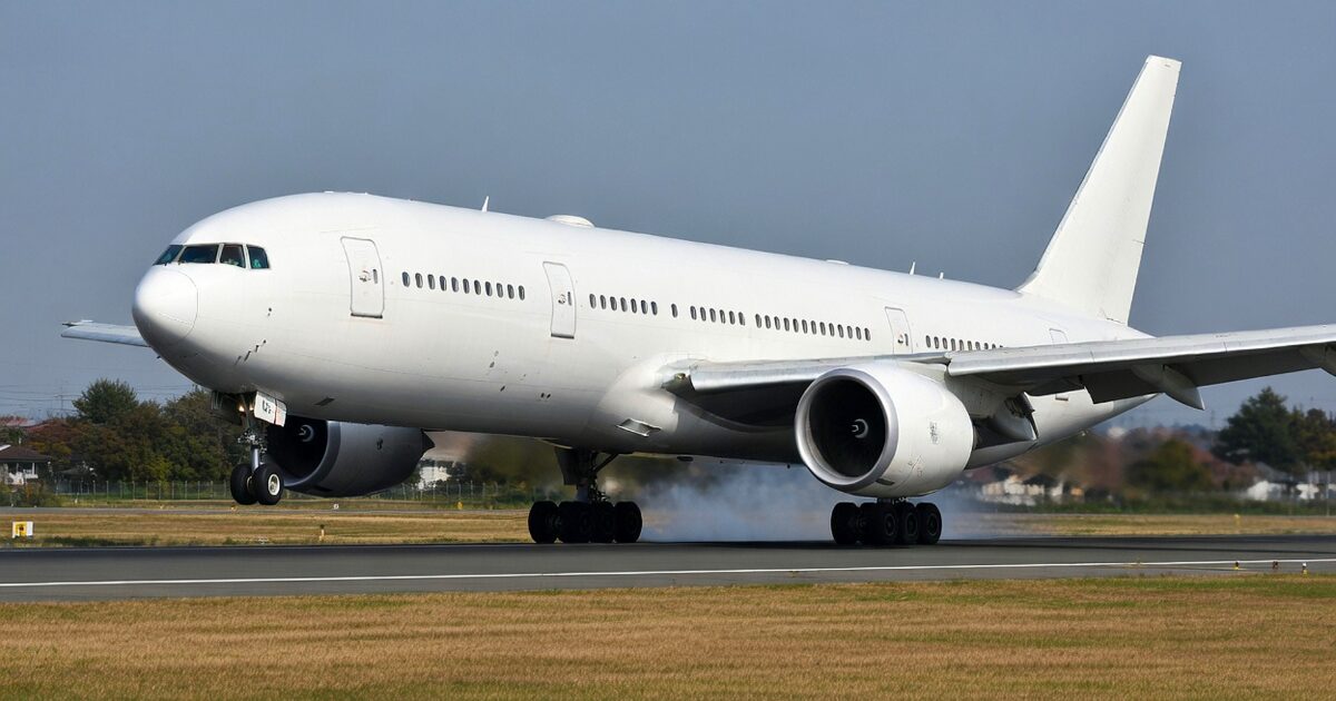 滑走路に着陸しタイヤスモークを上げる大型ジェット旅客機