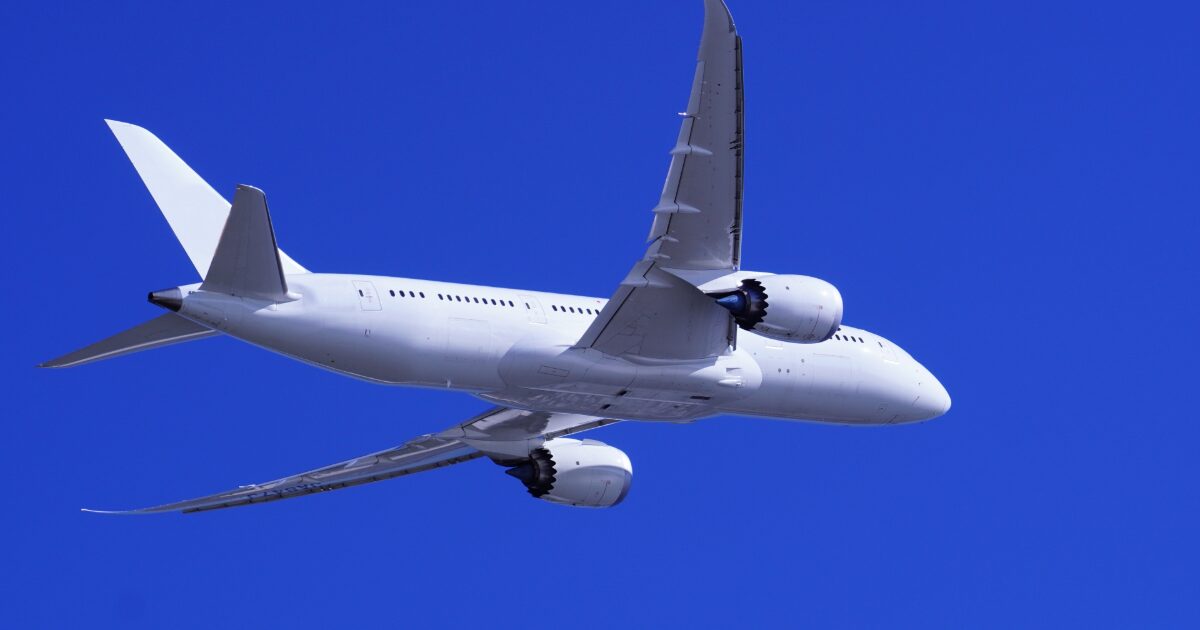 青空を背景に飛行するボーイング787ドリームライナー